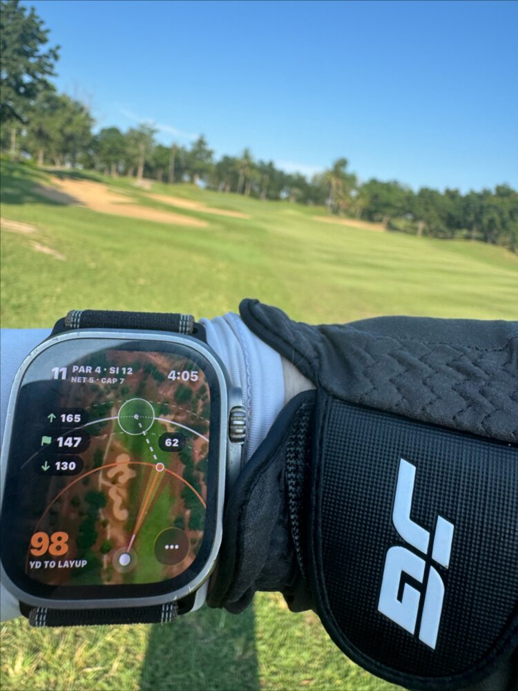 An Apple Watch on a golfer's wrist showing the hole map and distances